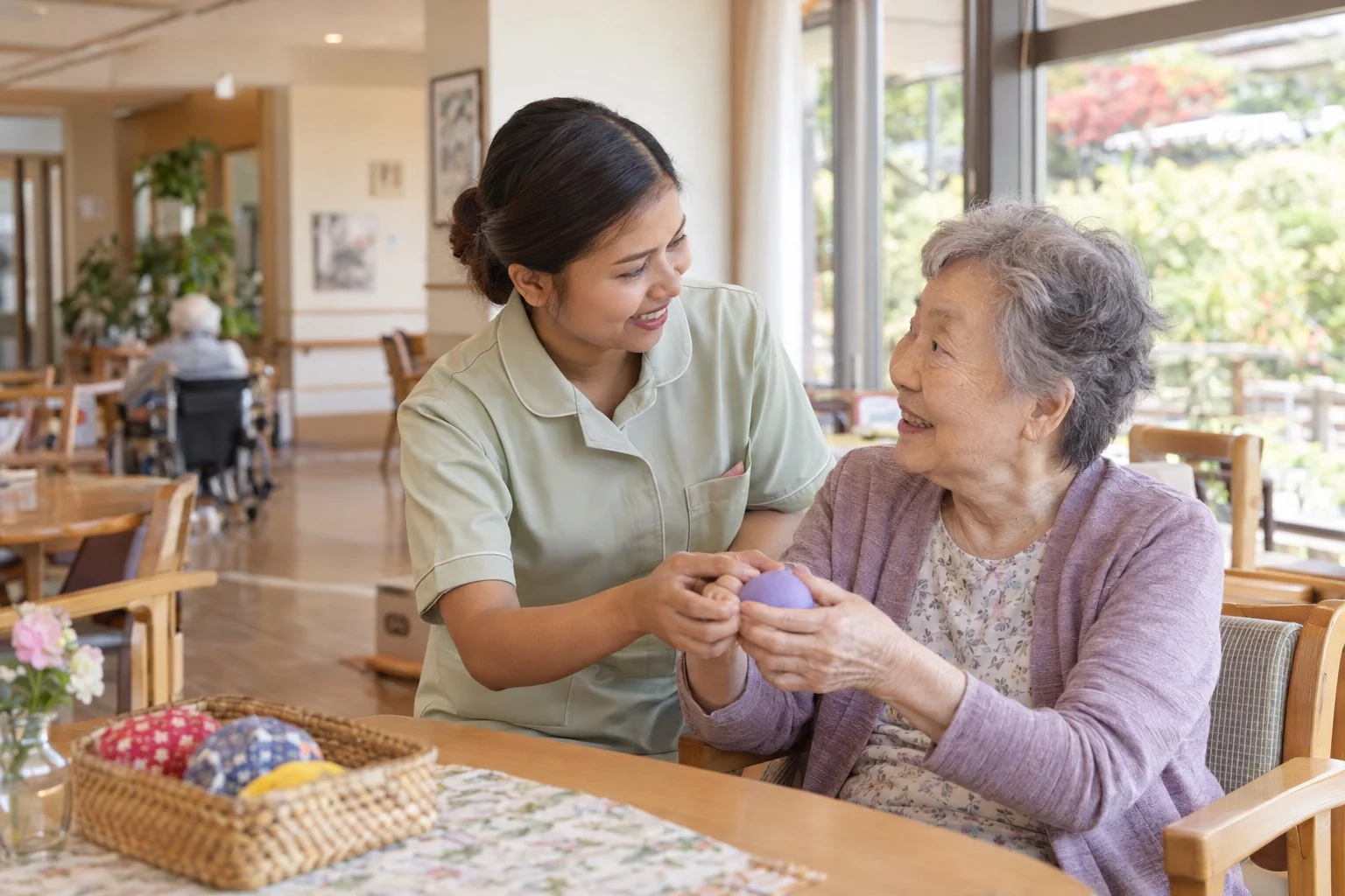A female caregiver supports an elderly resident during a hand exercise in a care facility